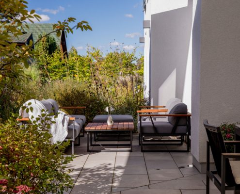 Eine Terrasse aus Naturstein mit Lounge-Möbeln