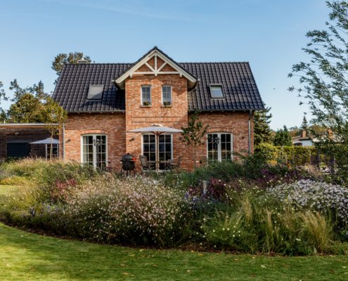 dichte Stauden als Insel vor einem Haus