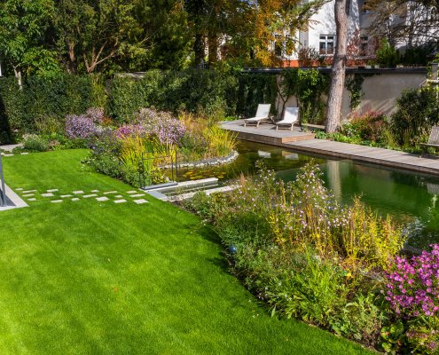 Garten mit Rasenfläche, Pflanzen und Schwimmteich