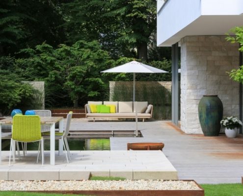 Ein Schwimmteich in einer Stadtvilla Ein Schwimmteich, eine Sitzgruppe und Sonnenschirm an einer Staeinterrasse