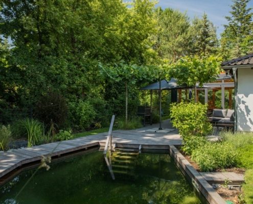 Schwimmteich mit einer Holzterrasse Schwimmteich mit einer Holzterrasse