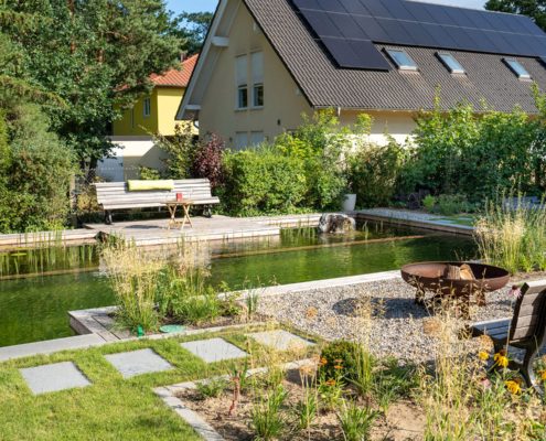 Hausgarten mit einem Schwimmtiech und Trittsteinen im Rasen
