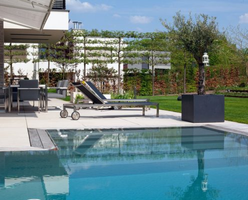 Natursteinterrasse mit einer Liege am Pool