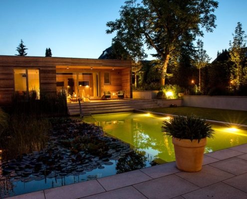 Abendbild: Hausgarten mit Schwimmteich und Sauna